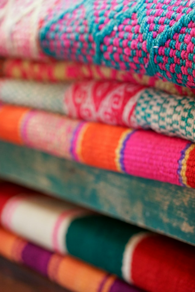 A stack of colorful woven fabrics.